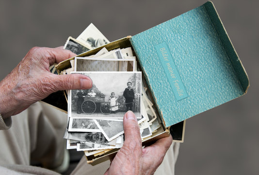 Senioren schaut sich alte Familienfotos an, Erinnerung an die Vergangenheit