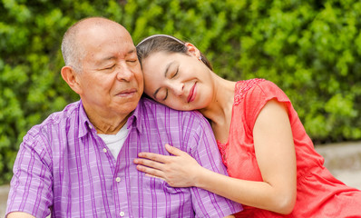 Close up of daughter hugging his father with love at outdoors in the park