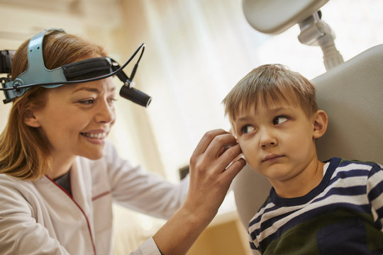ENT physician examining ear of a boy