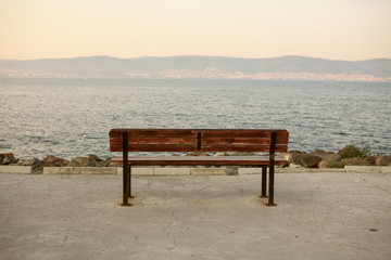 Naklejka na ściany i meble Wooden bench in front of the sea