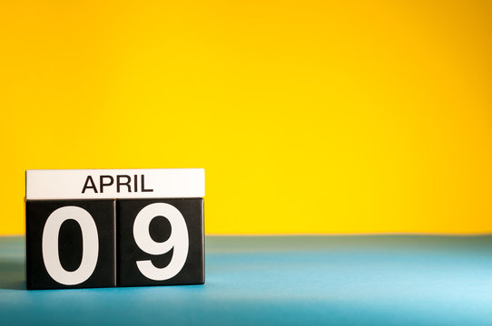 April 9th. Day 9 of april month, calendar on table with yellow background. Spring time, empty space for text