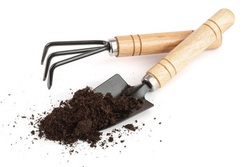 garden tools in soil isolated on white background