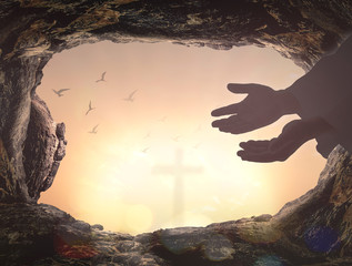 Ascension day concept: Silhouette Jesus Christ hands with empty tomb stone and birds flying over...