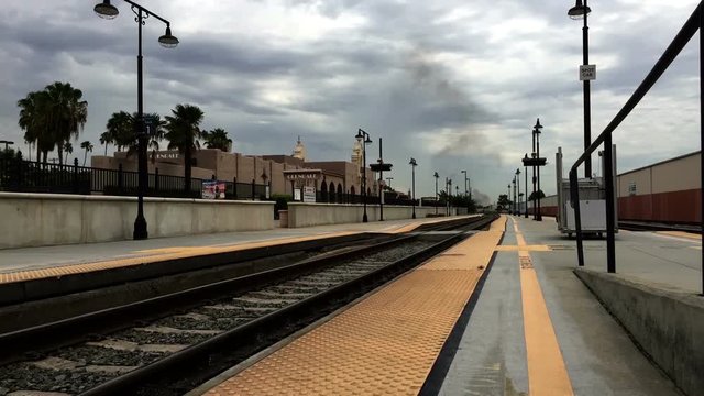 Black Smoke and approaching train at train station