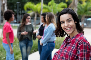 Laughing mexican young adult woman with girlfriends