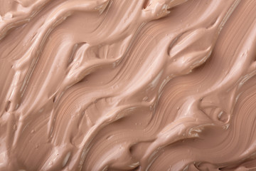 Beige liquid foundation makeup as a background. Top view. Flat lay pattern