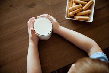 The view from the top. A glass of milk in the hands of the child.