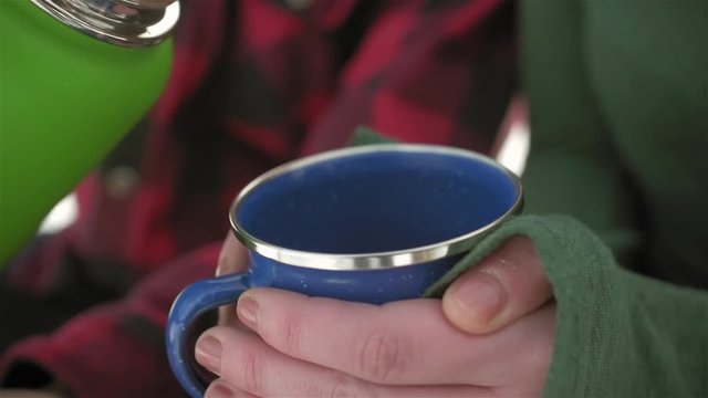 Close up shot of someone pouring some hot coffee into someone's cup