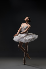 Ballerina in white tutu dancing in the dark