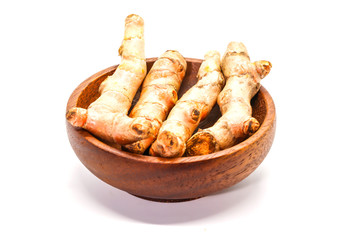Closeup of Fresh turmeric with wooden cup isolated on white background