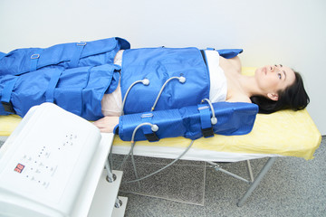 Procedure pressotherapy in clinic. Young sexy girl in costume