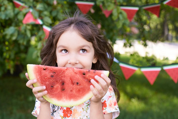 Juicy red watermelon slice. Little girl. Bright Grass. Summer sunny day