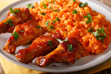 Nigerian food: spicy Jollof rice with fried chicken closeup. horizontal