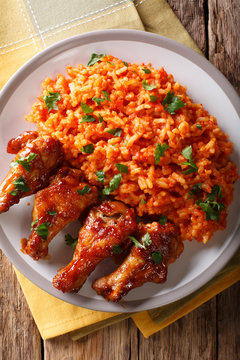 Classic Nigerian Jollof Rice with fried chicken wings close-up. Vertical top view