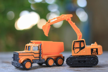 Dump toy truck Excavator machine toy yellow color on wooden