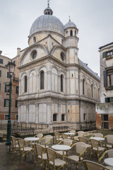 Naklejka na ściany i meble Venise, Italy - 03 12 2018: Vue extérieure de la façade de l'Eglise Santa Maria dei Miracoli, depuis la place avec tables et chaises