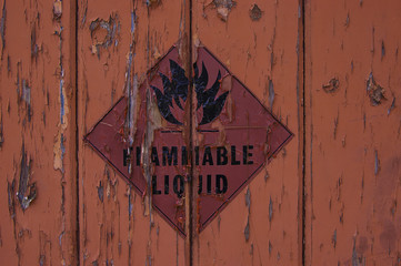 Peeling paint and danger sign due to long exposure to changing weather.
