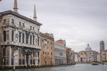 Fototapeta na wymiar Venise, Italy - 03 12 2018: Le Grand Canal de Venise, avec bateaux, belles façades colorées, tour et dôme d'église