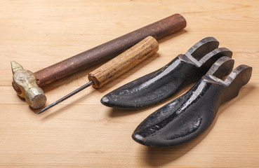 old shoemaker tools on wooden table