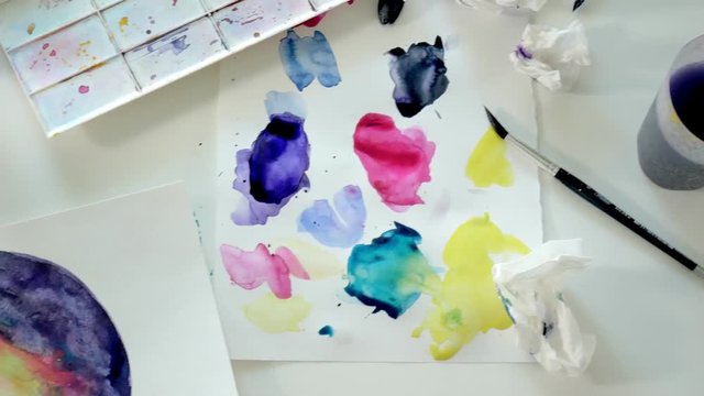 Adult women paint with colored watercolor paints in an home studio close up