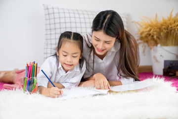 Asian happy loving family. pretty young mother write a book