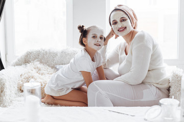 Mom with her daughter making clay face mask