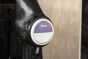Close up view of a nozzle hanging at a gas pump for diesel fuel