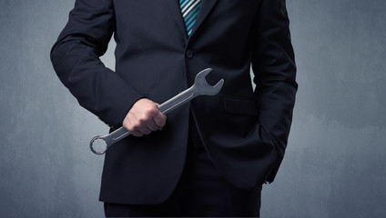 Businesman standing with tool on his hand