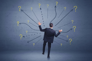 Businessman standing in front lines and question mark signs concept