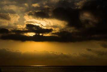 A beautiful sunset on the sea is in the gold clouds