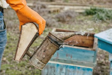 Beekeeper collecting honey in Bulgarian farm.Selective focus.