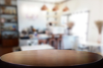 Selected focus empty brown wooden table and Coffee shop or restaurant blur background with bokeh image. for your photomontage or product display.