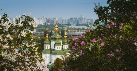 Botanical garden with blooming lilac, spring landscape, St. George Cathedral of the Vydubychi Monastery, view on Dnipro river, Kyiv, Ukraine