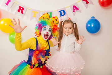 clown girl on the birthday of a child. A party for a child. shy Baby