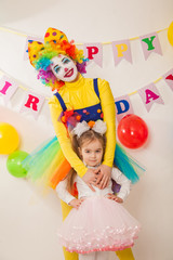 Obraz na płótnie Canvas clown girl on the birthday of a child. A party for a child. shy Baby