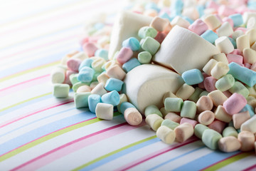 Close up of various marshmallows on a striped background.