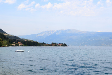 Lake Garda and mountain panorama with boat in Salo, Italy