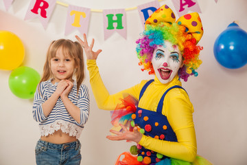 clown girl on the birthday of a child. A party for a child. Emotional Child fools around