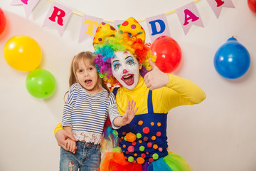 clown girl on the birthday of a child. A party for a child. Emotional Child fools around