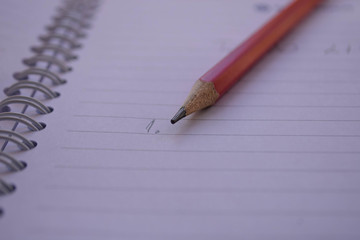 Red pencil with notebook on wooden table Save creative ideas on paper. Basic equipment before the computer. On the rustic table background