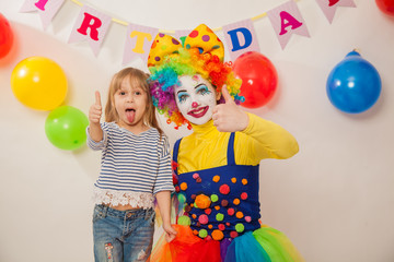 clown girl on the birthday of a child. A party for a child. Emotional Child fools around