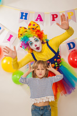 Fototapeta na wymiar clown girl on the birthday of a child. A party for a child. Emotional Child fools around