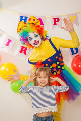 clown girl on the birthday of a child. A party for a child. Emotional Child fools around