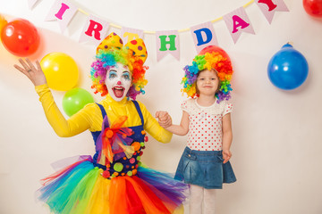 Obraz na płótnie Canvas clown girl on the birthday of a child. A party for a child. A child in a clown wig
