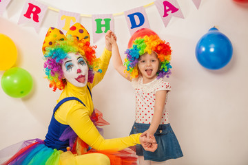 clown girl on the birthday of a child. A party for a child. A child in a clown wig