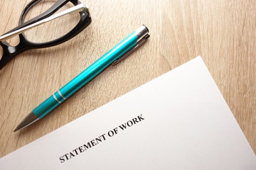 Statement of work, pen and eyeglasses on desk