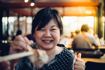 Asian woman in barbeque yakiniku grill restaurant