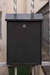 Black modern metal mailbox on outside doors.