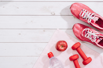 fitness concept with dumbbells and red apple - sport and leisure