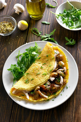 Omelette stuffed with mushrooms, chicken meat, greens